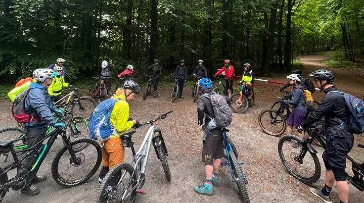 Gruppe von Mountainbiker*innen steht mit ihren Rädern auf einem Waldweg. | © DAV Dortmund