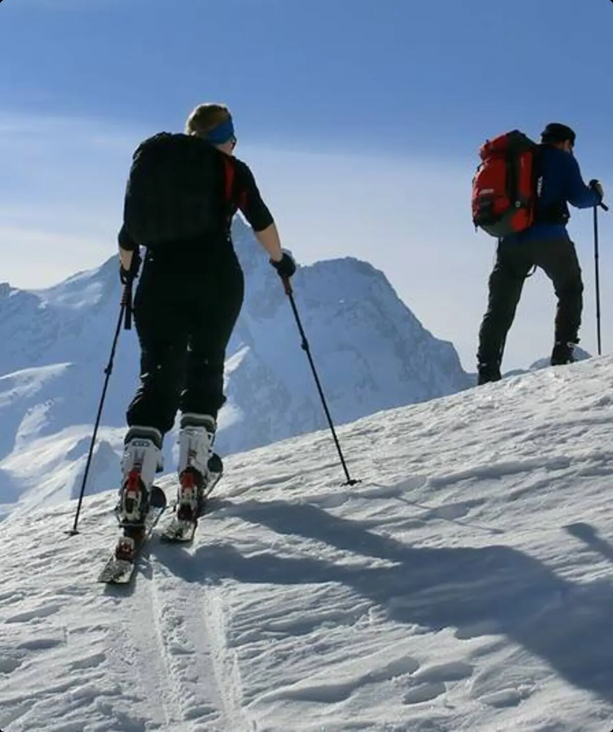Drei Skitourengeher*innen steigen mit Tourenski bei gutem Wetter durch die verschneite Berglandschaft. | © DAV Dortmund