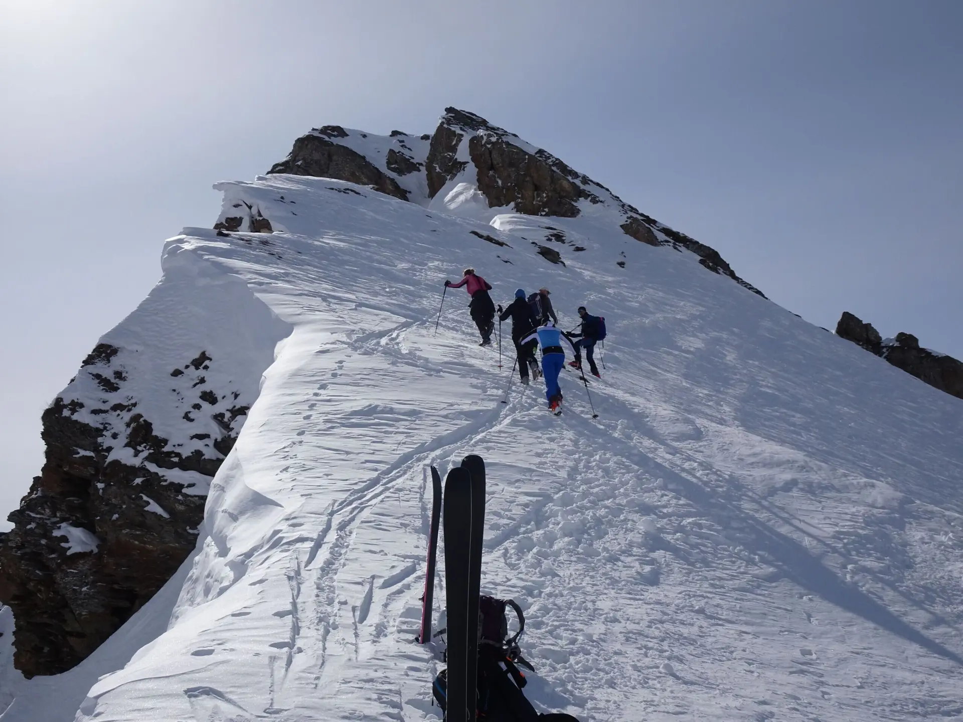 Gruppe von Personen steigt bei Sonnenschein mit Tourenski einen steilen Schneegrat hinauf. | © DAV Dortmund
