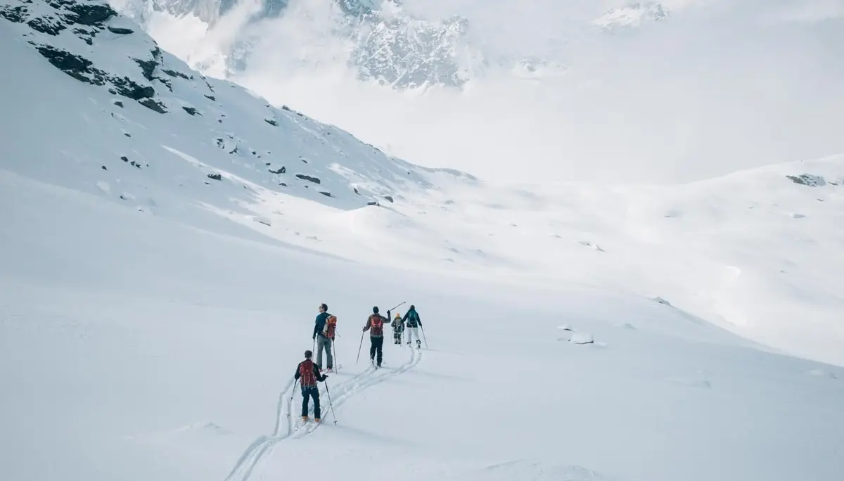 5 Skitourengeher in einem weiten Tal | © Tim Hilbrand