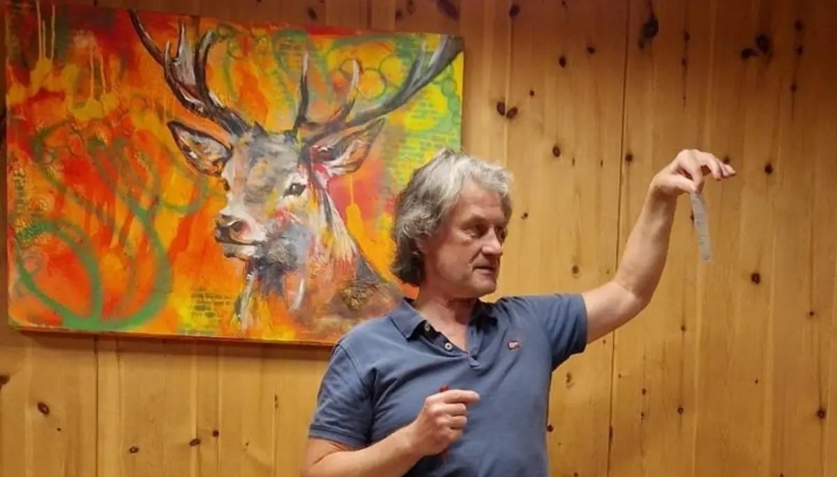 Mann hält Rede vor Holzwand mit Bild von einem Hirschen | © Dietmar Fischer