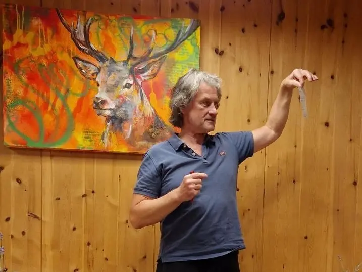 Mann hält Rede vor Holzwand mit Bild von einem Hirschen | © Dietmar Fischer