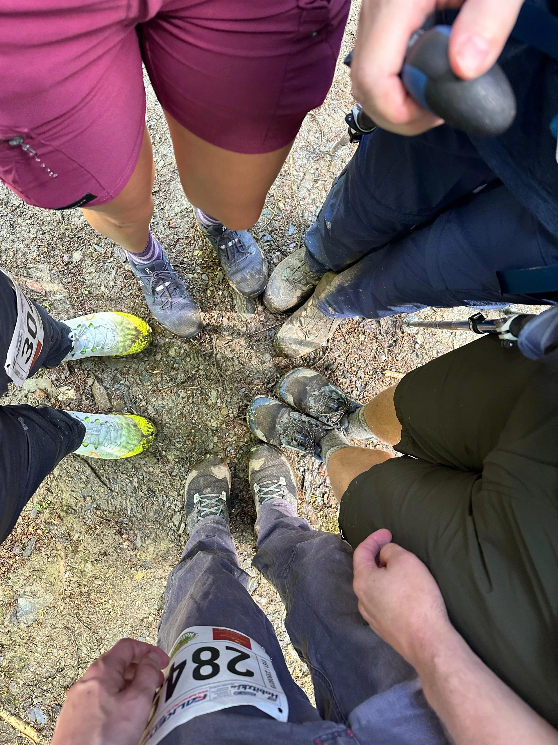 Blick auf die Füße einer Gruppe, teilweise mit Startnummern und Wanderausrüstung. | © DAV Dortmund