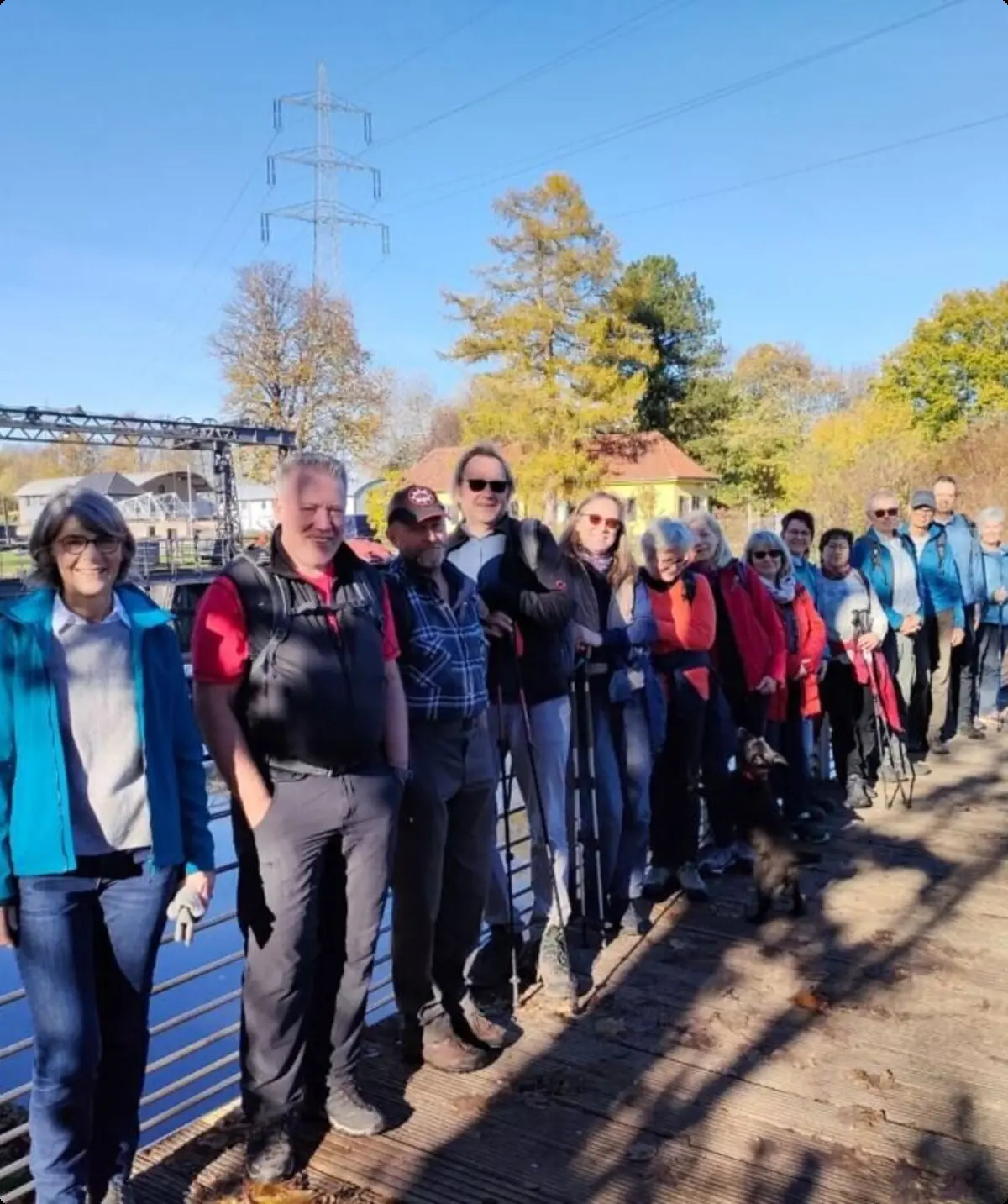 Große Wandergruppe steht auf einem Steg an einem Fluss oder Kanal bei sonnigem Herbstwetter. | © DAV Dortmund