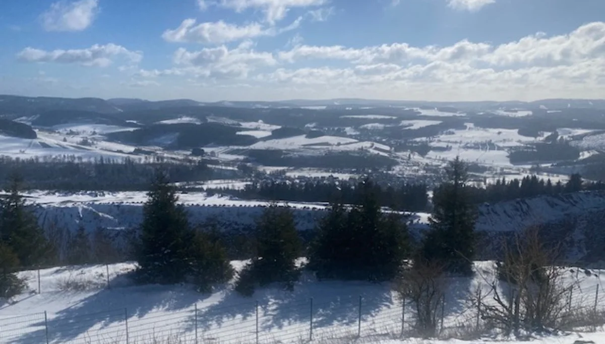 Schneebedeckte Hügellandschaft mit Wäldern und weitem Blick unter blauem Himmel mit Wolken. | © DAV Dortmund