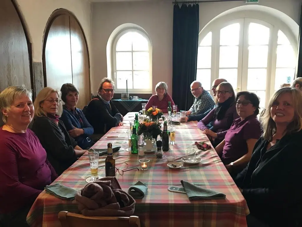 Eine Wandergruppe sitzt gemeinsam an einem gedeckten Tisch in einem Gastraum. | © DAV Dortmund