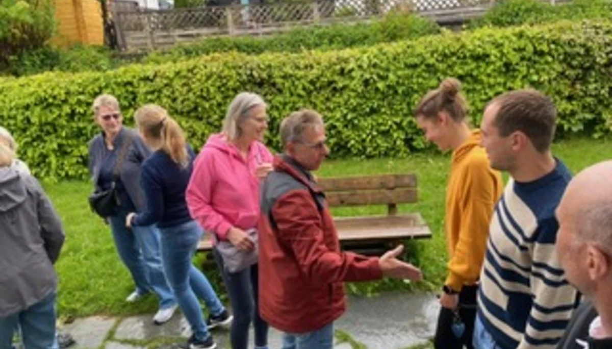 Mehrere Menschen stehen im Garten und unterhalten sich. | © DAV Dortmund