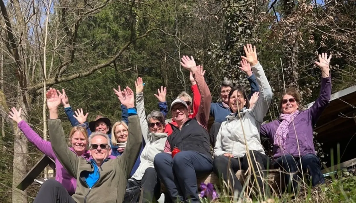 Verschiedene Menschen machen Pause auf einer Bank und winken | © DAV Dortmund