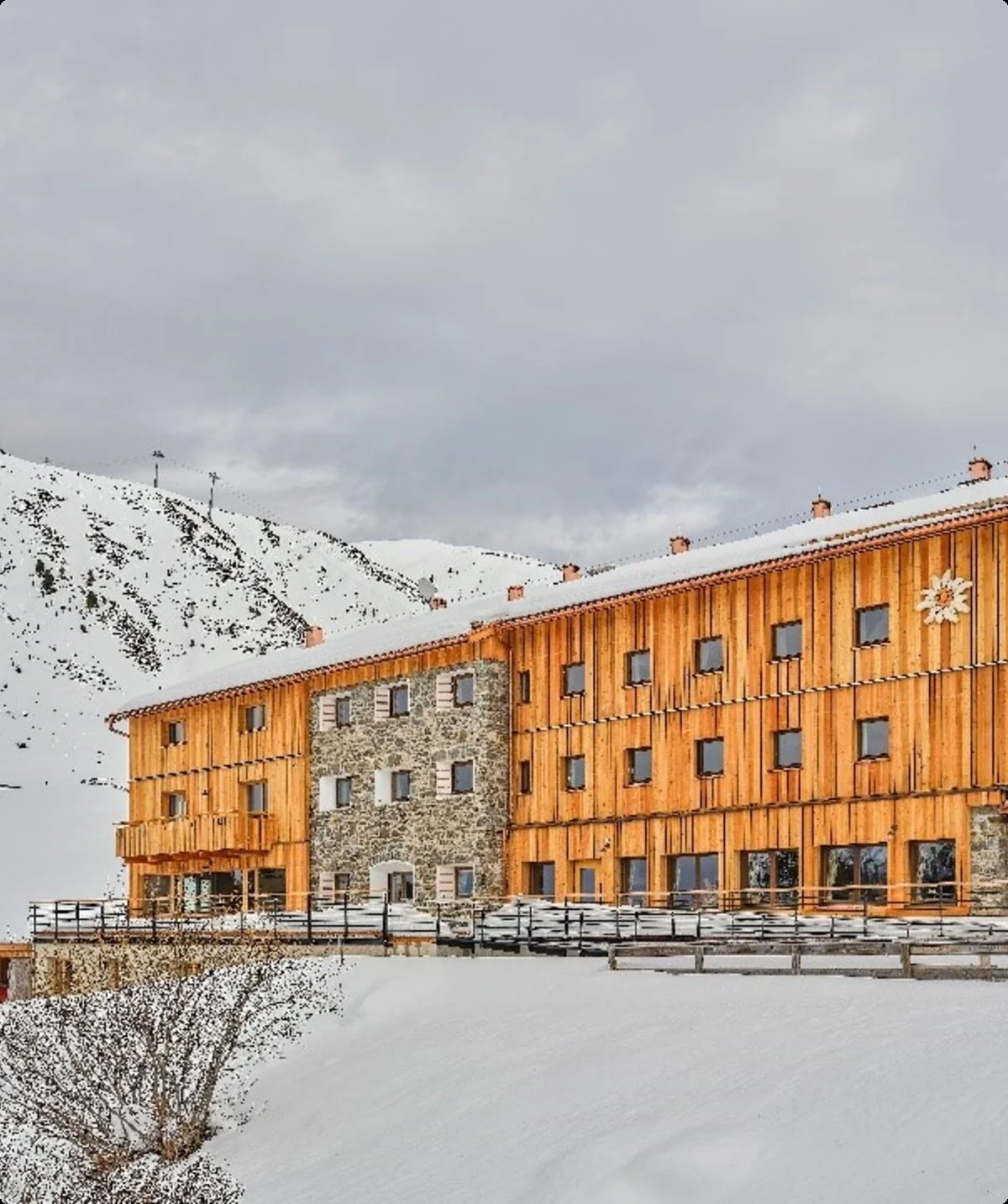 Die Dortmunder Hütte in winterlicher Landschaft mit Holzfassade und angrenzendem Berghang. | © DAV Dortmund