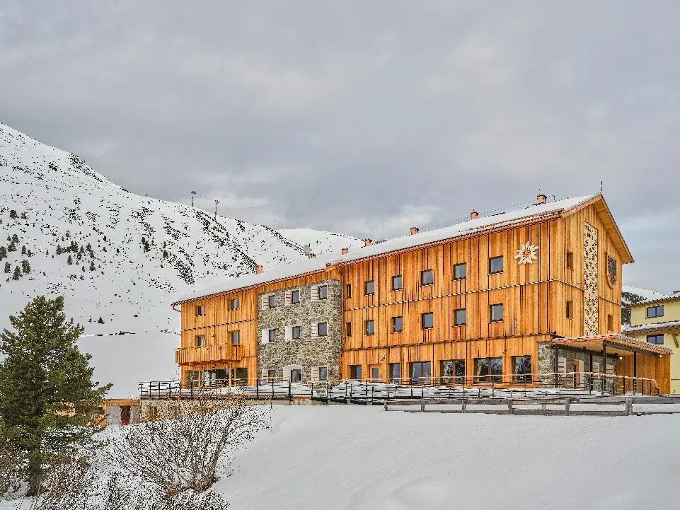 Die Dortmunder Hütte in winterlicher Landschaft mit Holzfassade und angrenzendem Berghang. | © DAV Dortmund
