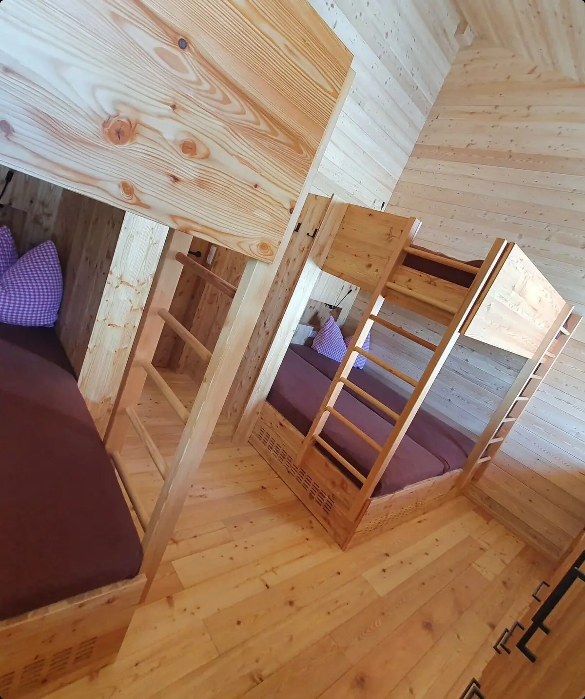 Mehrere Schlafkojen mit Matratzen und Holzrahmen in einem modern eingerichteten Gruppenraum. | © DAV Dortmund