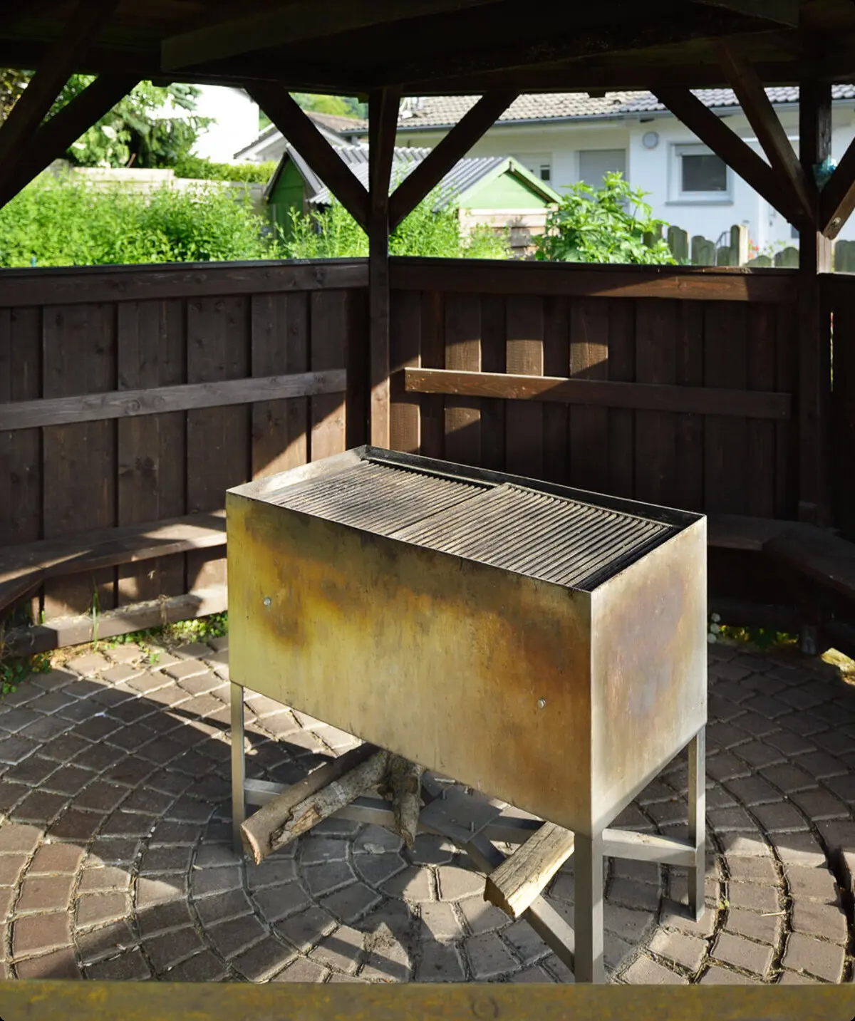 Ein Grill steht unter einem hölzernen Pavillon mit umlaufender Sitzbank im Freien. | © DAV Dortmund