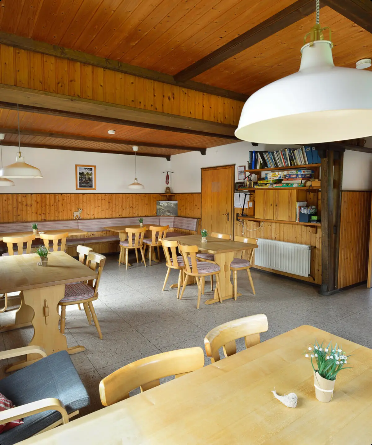 Ein heller Gastraum mit Holzmöbeln und mehreren Tischen in einer Berghütte, gemütlich eingerichtet. | © DAV Dortmund