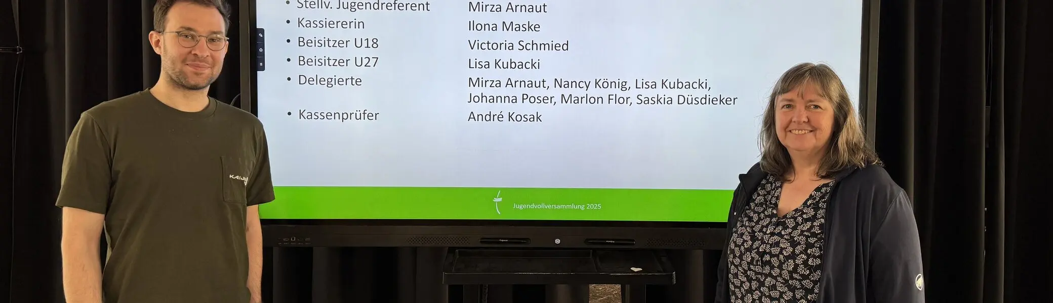 Zwei Personen stehen vor Bildschirm mit Namen des neu gewählten Jugendausschusses vom 29. März 2025. | © DAV Dortmund