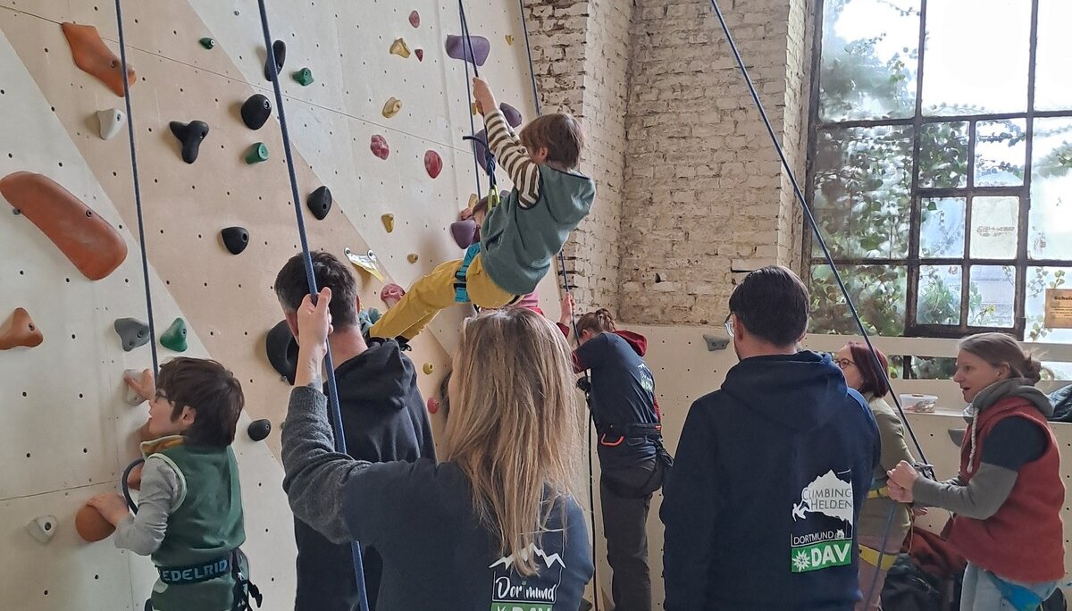 Kinder werden beim Seilklettern an einer Indoor-Kletterwand von Erwachsenen gesichert. | © DAV Dortmund