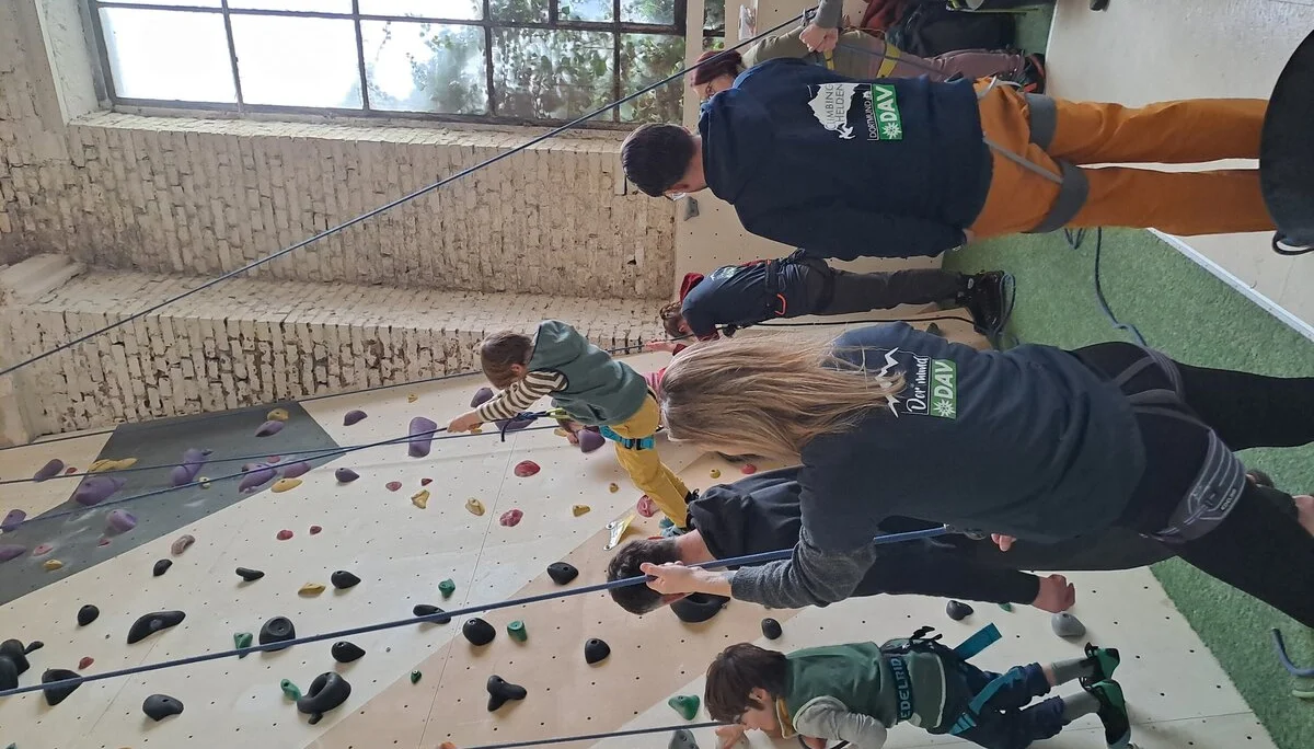 Kinder werden beim Seilklettern an einer Indoor-Kletterwand von Erwachsenen gesichert. | © DAV Dortmund
